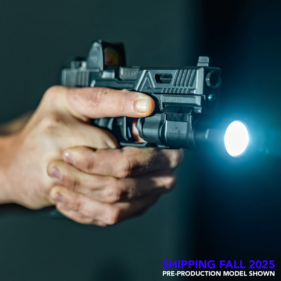 Hand holding a pistol with a tactical light attached to the bottom, displaying a bright beam of light.
