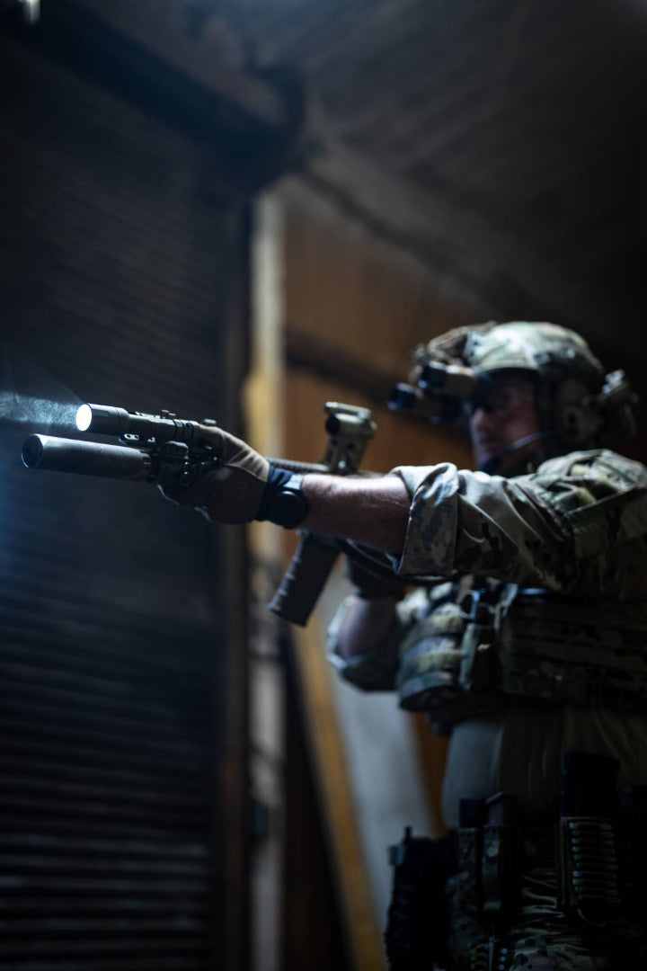 Man in tactical gear holding a rifle.