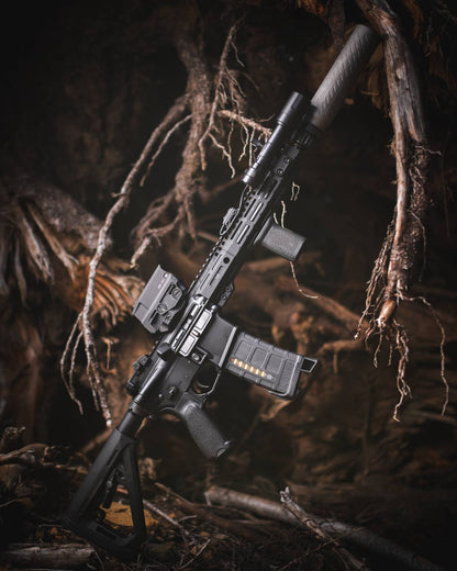 black rifle with black Rein flashlight in the forest