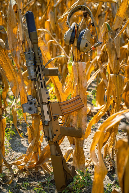 Tan rifle with FDE Rein flashlight in a corn field