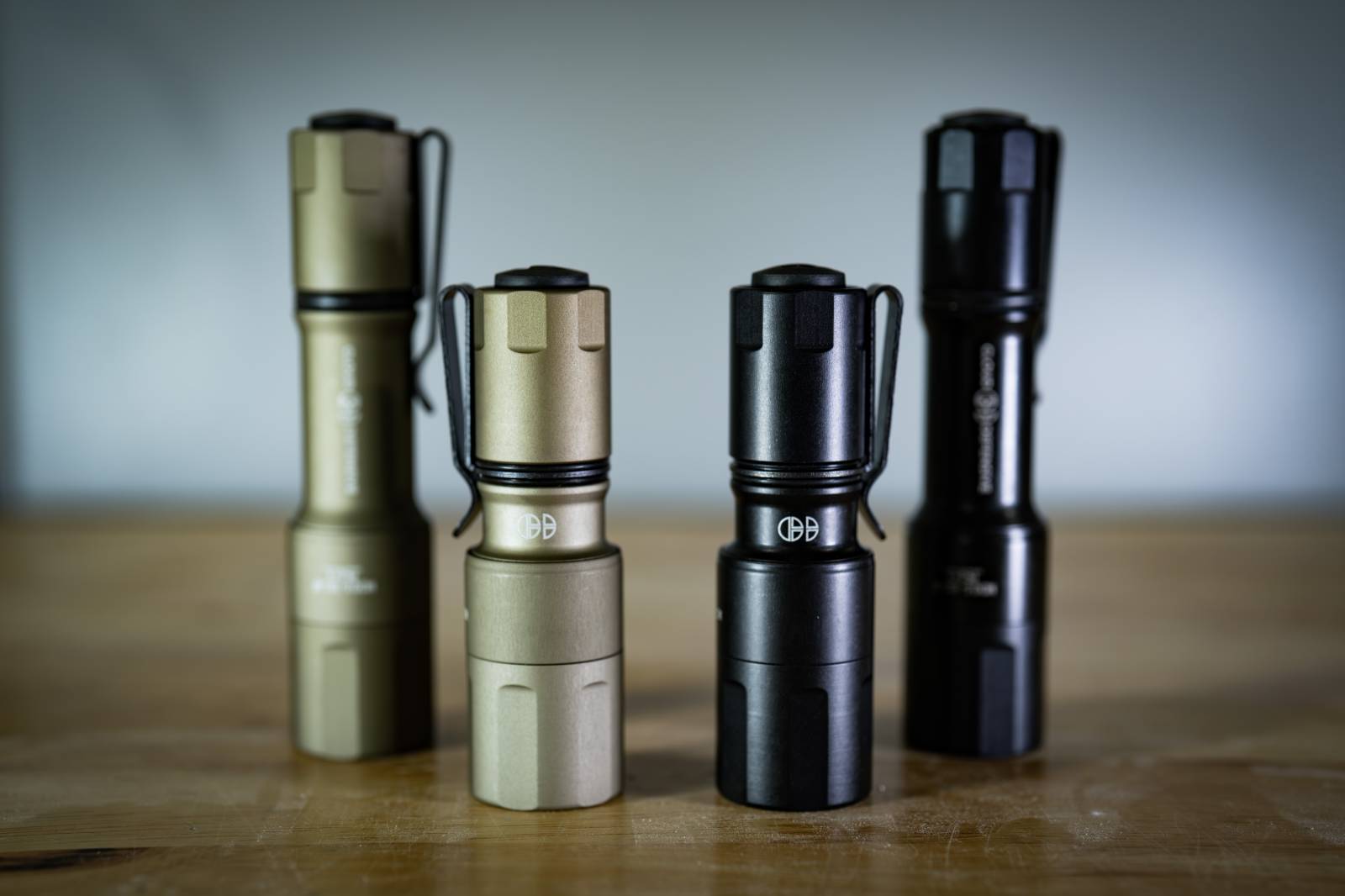 Photo of black and FDE MCH and MCH Micro flashlights on a table.